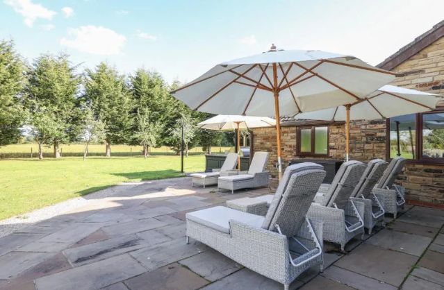 Outdoor terrace with sun loungers and parasols at Skylark Retreat, a luxury East Yorkshire hen party house.