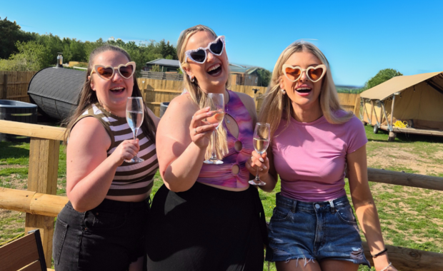 Hen group celebrating at HenFest™ festival-style glamping weekend – exclusive GoHen experience.